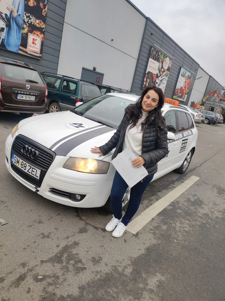 Cursantă Auto Zel cu documentele de examen lângă mașina școlii