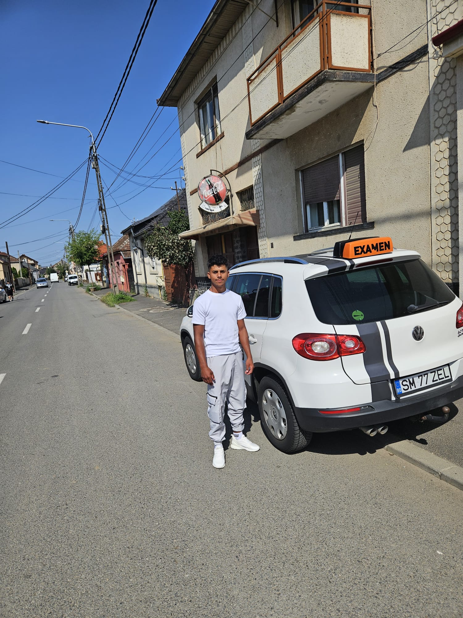 Cursant Auto Zel lângă VW Tiguan cu caseta EXAMEN pe plafon