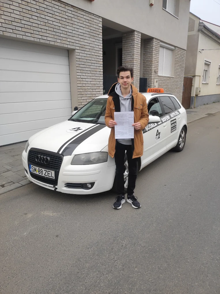 Absolvent Auto Zel cu permisul obținut, lângă Audi A3 al școlii
