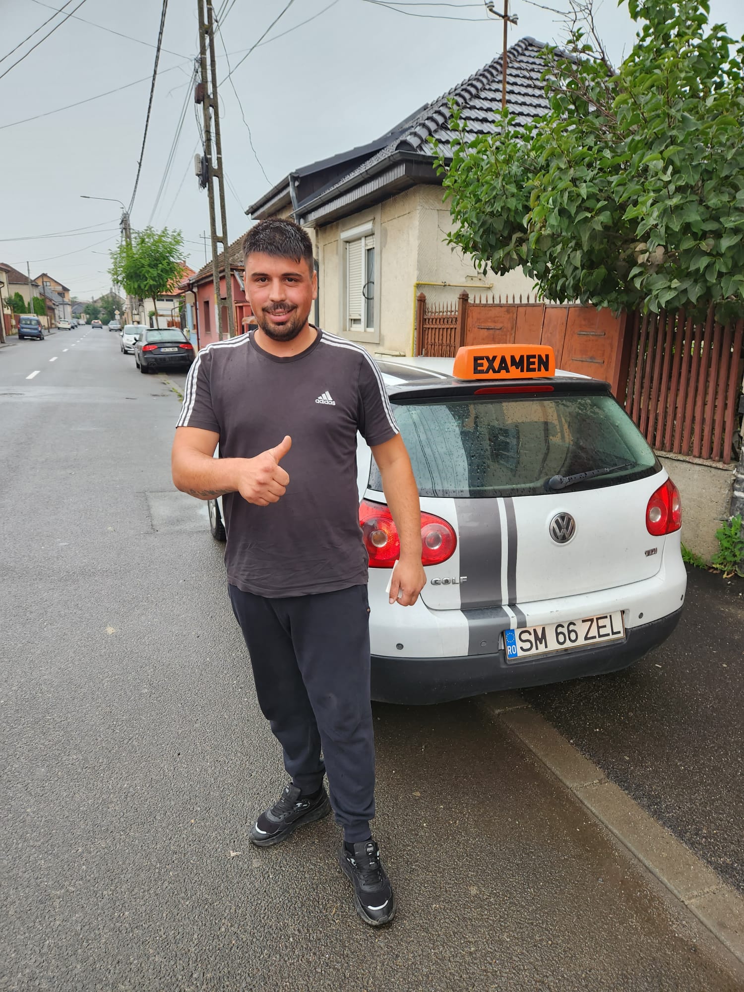 Cursant Auto Zel mulțumit lângă VW Golf cu caseta EXAMEN